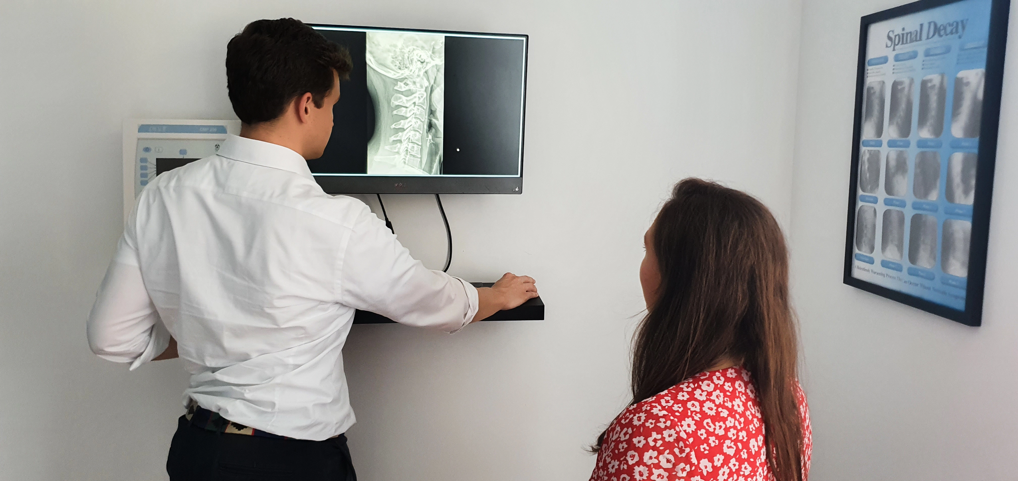 Tom Blayney (Doctor of Chiropractic) reviewing x ray findings with a patient.